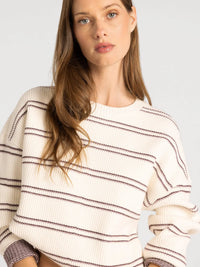 Cream-colored ribbed knit thread & supply ely sweater with dark brown stripes and textured cuffs in soft knit material