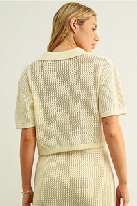 Cream-colored short-sleeved crochet v-neck cardigan with textured openwork pattern and ribbed v-neck collar