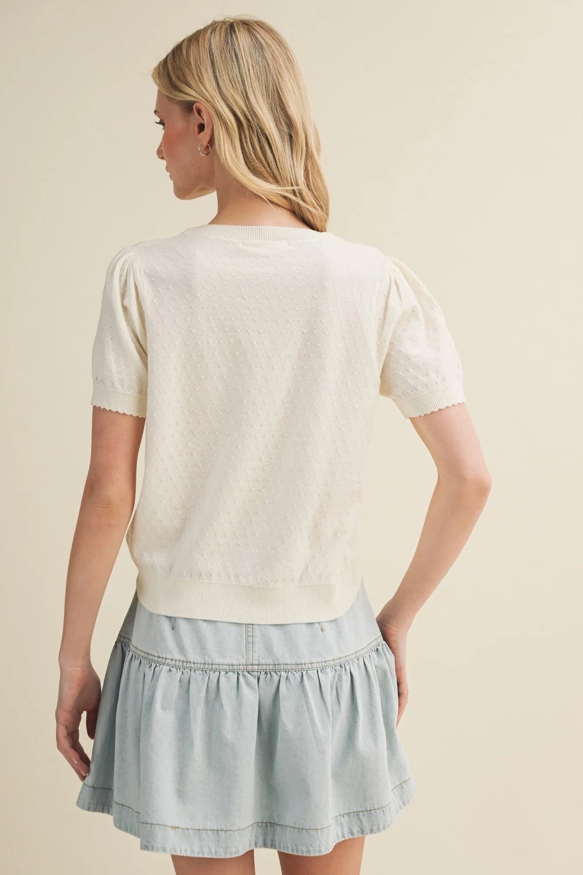 Cream-colored starburst pointelle puff sleeve top with short sleeves and textured knit pattern for stylish wear