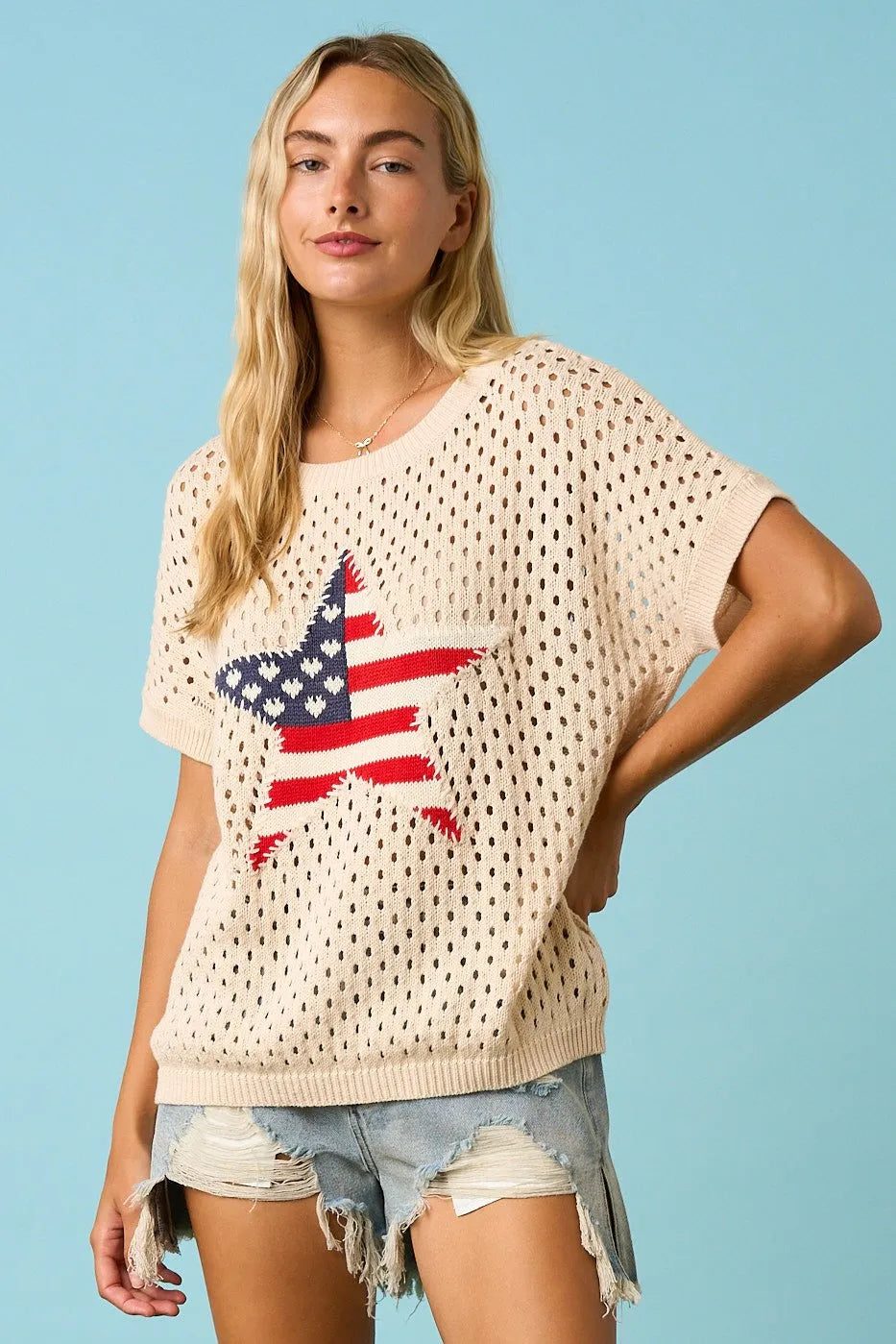 Cream-colored short-sleeved usa star patch open knit sweater top with perforated texture and american flag star design