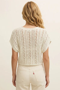 Cream-colored short-sleeved ballast crochet sweater top with openwork pattern and ribbed neckline in knitted fabric
