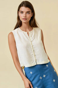 Cream-colored viscose blend button sleeveless blouse with button-down front and subtle pleats at the hem