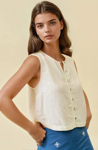 Cream-colored sleeveless viscose blend button front top with subtle sheen and delicate floral embroidery on hem