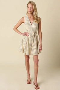 Cream-colored mila polka dot button front mini dress with sleeveless v-neckline and fitted waist tied with belt