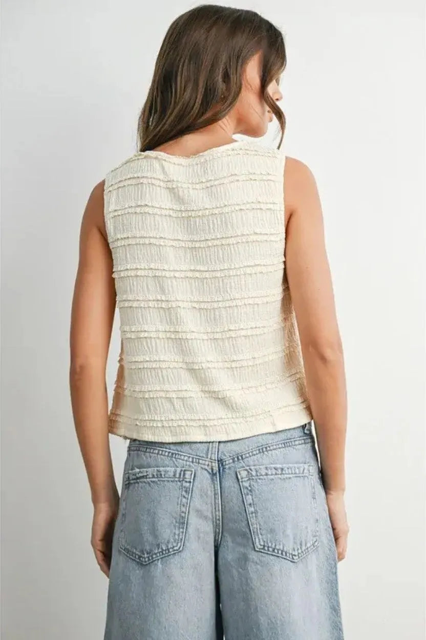 Cream-colored sleeveless textured button top with horizontal ruched detailing for women’s boho chic clothing