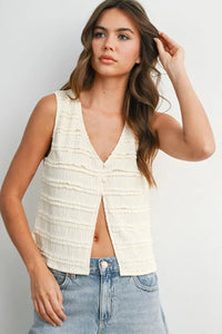 Cream-colored textured button front sleeveless top with ruffled detailing and v-neckline for women’s boho chic clothing