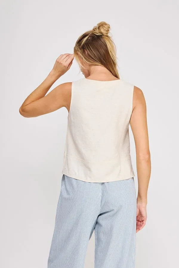 Cream-colored sleeveless linen button collar textured top with a simple relaxed fit perfect for casual wear