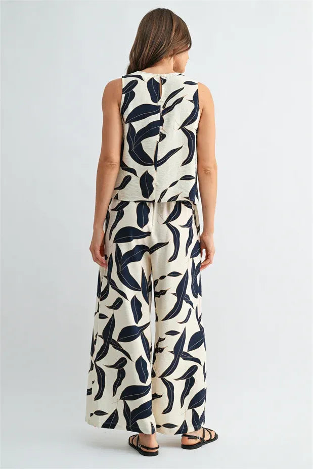 Cream-colored leaf print button sleeveless top and matching wide-leg pants set with bold navy blue leaf print for women’s boho style
