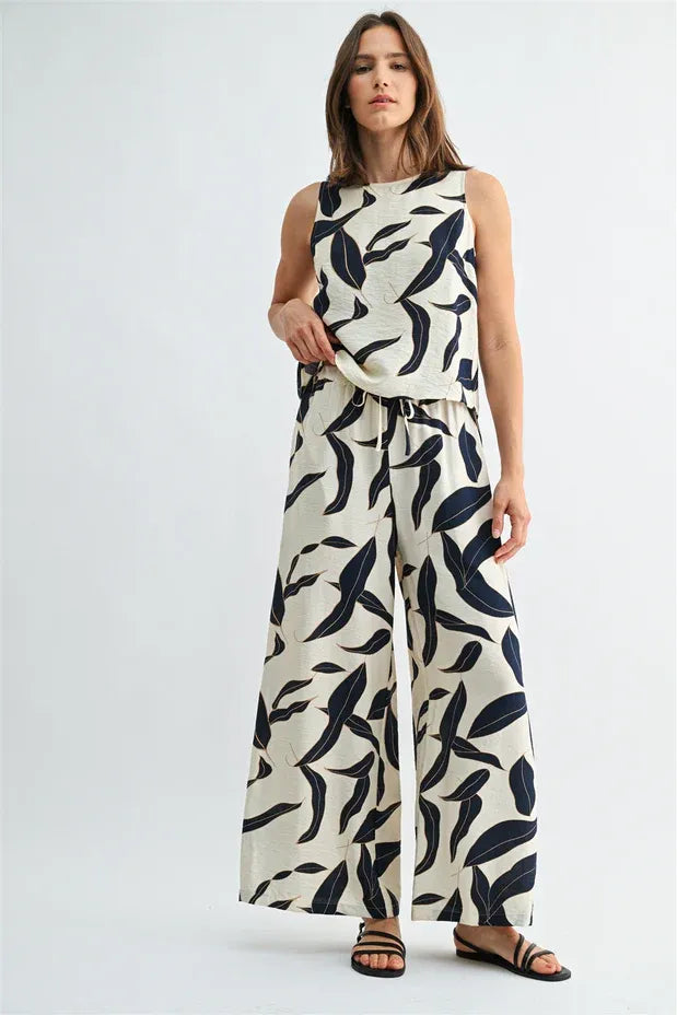 Cream-colored sleeveless top and leaf print elastic waist wide leg pants set with bold black leaf pattern