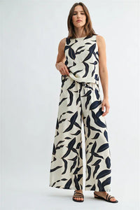 Cream-colored sleeveless top and leaf print elastic waist wide leg pants set with bold black leaf pattern