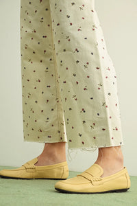 Cream-colored suede loafers paired with multi color floral print stretched pants featuring a subtle floral print design