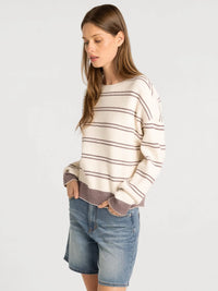 Cream-colored thread & supply ely sweater with thin black stripes and textured brownish-purple hem detailing