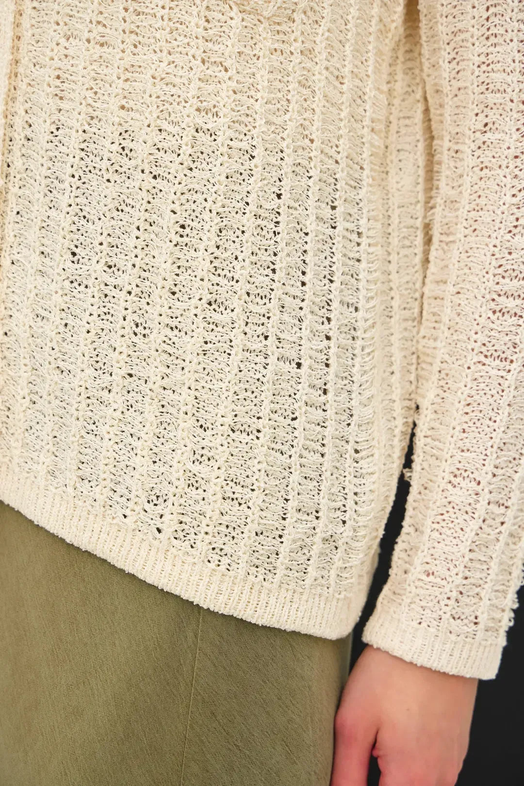 Cream-colored breezy textured knit cardigan with ribbed pattern and frayed edges