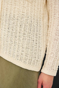 Cream-colored breezy textured knit cardigan with ribbed pattern and frayed edges