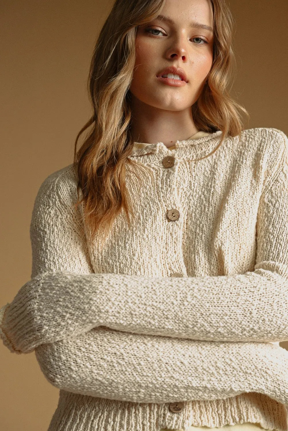Cream-colored textured sweater knit cardigan with wooden buttons in button front sweater knit cardigan style