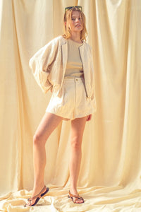 Cream-colored textured knit floral jacquard zip blazer with relaxed fit and subtle embroidery details