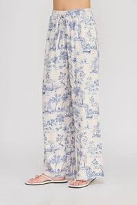Cream-colored wide leg pants with blue toile print, lightweight fabric, and elastic tie waist for comfort and style