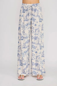 Cream-colored wide-leg pants with a blue toile print featuring an elastic tie waist for a comfortable fit