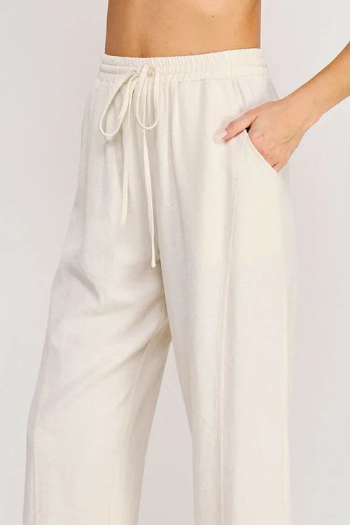 Cream-colored rayon linen blend relaxed tapered pants with elastic waistband and matching drawstring for comfort