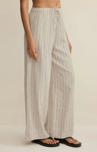 Cream-colored henri striped wide leg pants with thin black vertical stripes and elastic waistband with drawstring