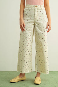 Cream-colored wide-leg floral print stretched pants in lightweight denim with soft pink and green floral patterns