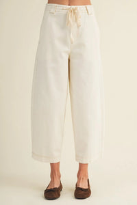Cream-colored pull on baggy fit pants with wide-leg design drawstring waist and rolled cuffs for casual wear