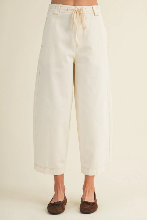 Cream-colored pull on baggy fit pants with wide-leg design drawstring waist and rolled cuffs for casual wear