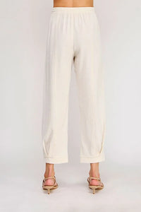 Cream-colored rayon linen blend relaxed tapered pants with wide legs soft flowing fabric and rolled cuffs