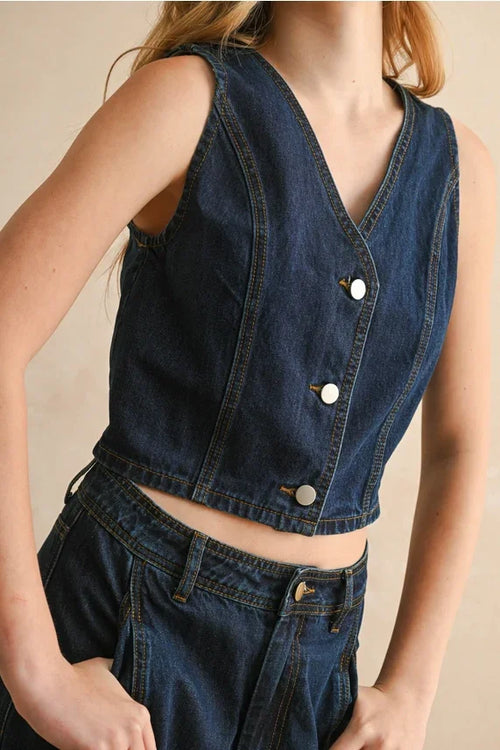 Dark blue sleeveless denim vest with V-neck and white buttons for women’s boho chic clothing