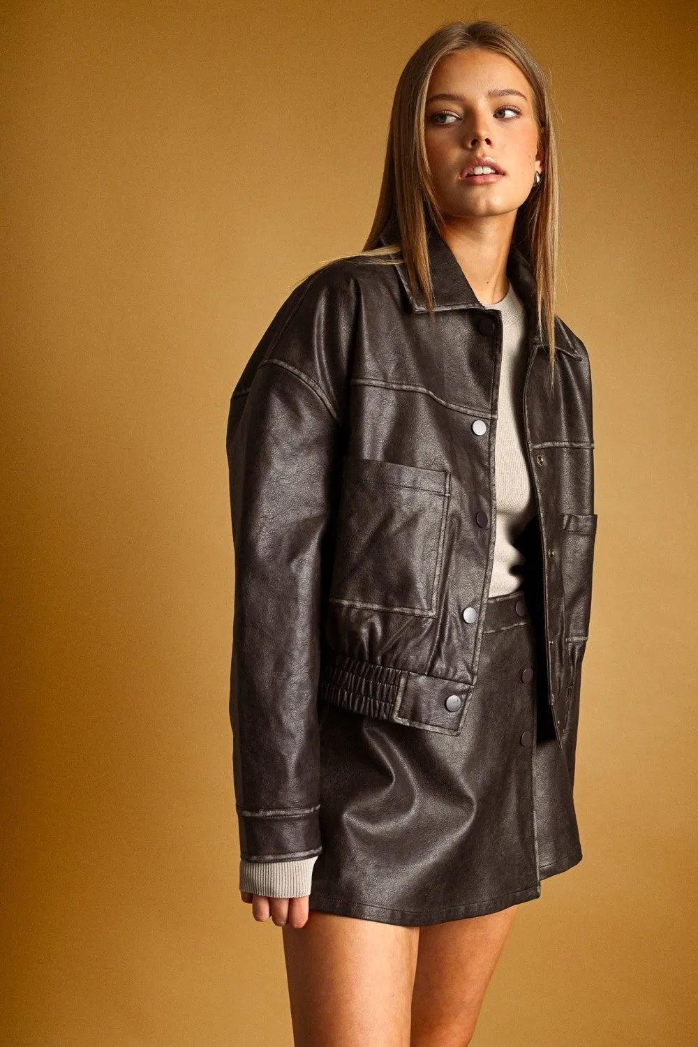 Dark brown faux leather washed effect button front jacket with relaxed fit and contrasting light gray ribbed cuffs