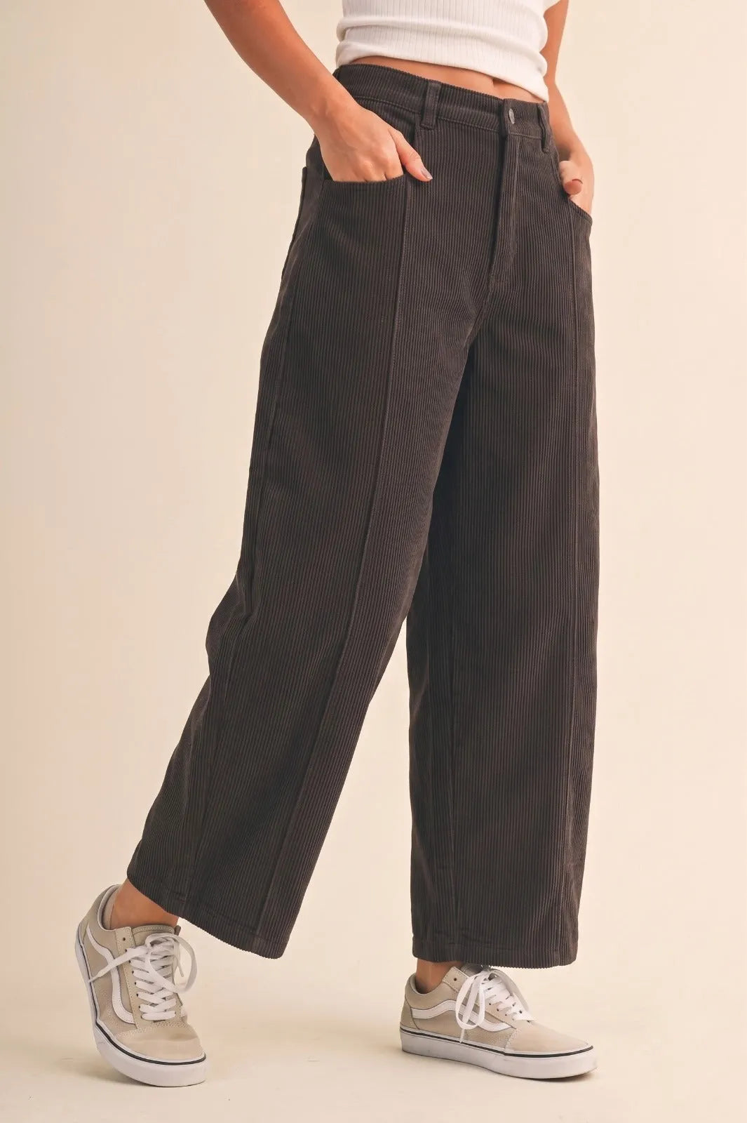 Dark charcoal mid rise corduroy barrel pants with vertical ribbed texture and relaxed tapered wide-leg fit