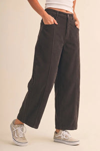 Dark charcoal mid rise corduroy barrel pants with vertical ribbed texture and relaxed tapered wide-leg fit
