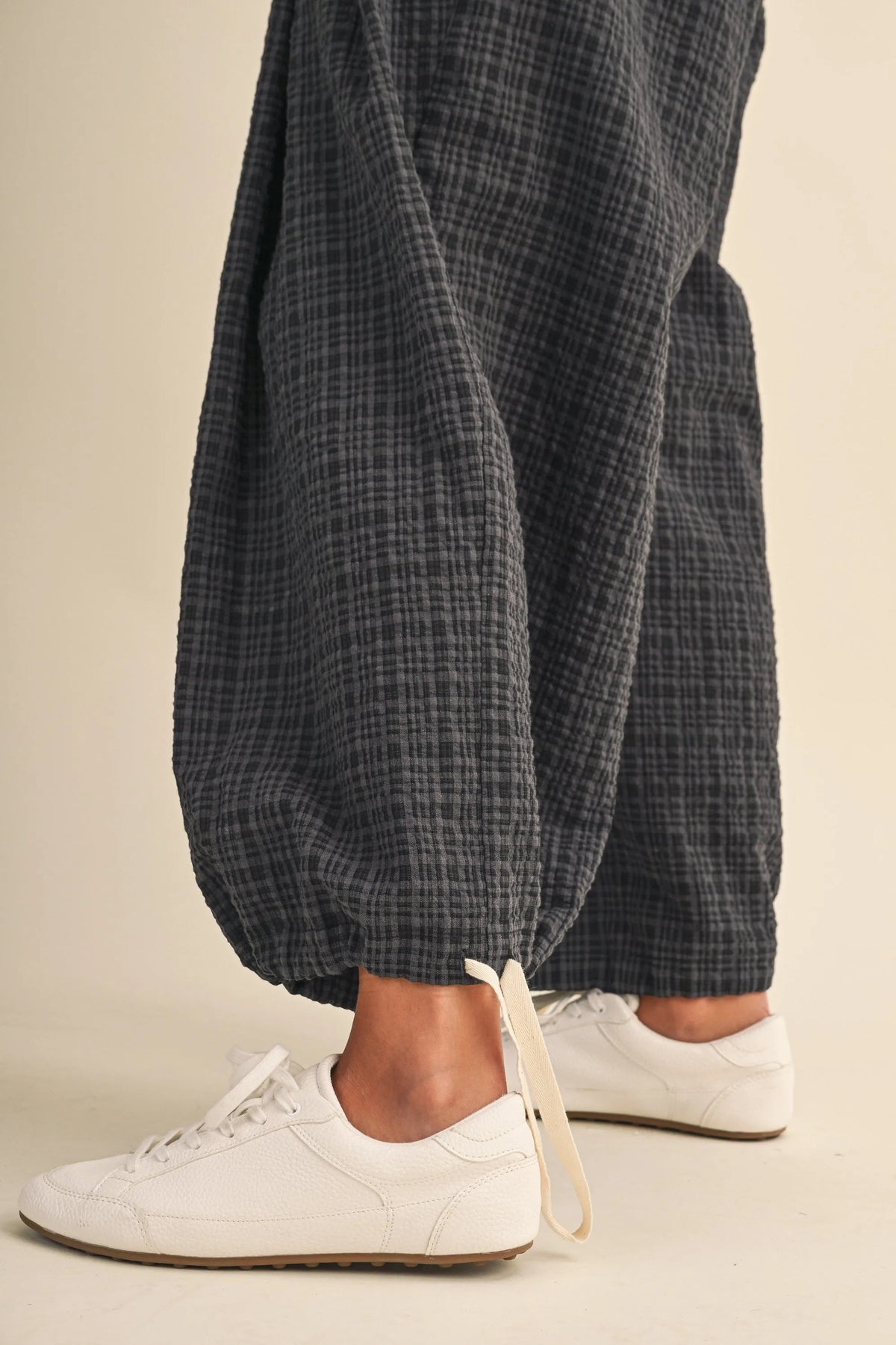 Dark gray checkered cotton trousers with drawcord waistline plaid and adjustable ankles for relaxed loose fit wear
