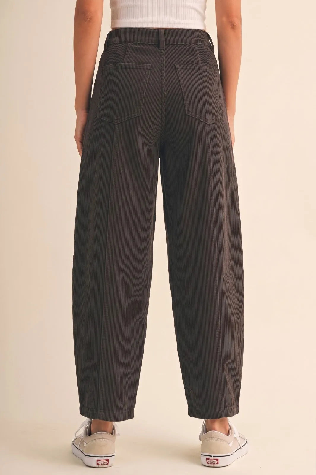 Dark gray mid rise corduroy barrel pants with vertical stripes and two back pockets shown from the back side