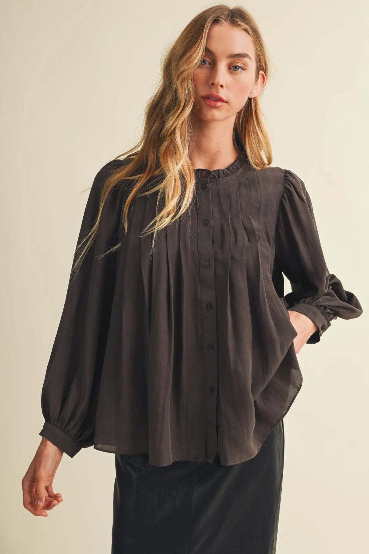 A dark gray long-sleeved blouse with a pintuck bib ruffle collar and button-down front for elegant wear