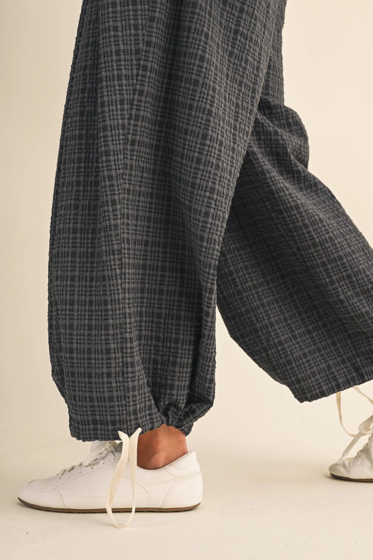 Dark gray plaid cotton trousers with a relaxed fit featuring drawcord waistline plaid and adjustable ankles waistband