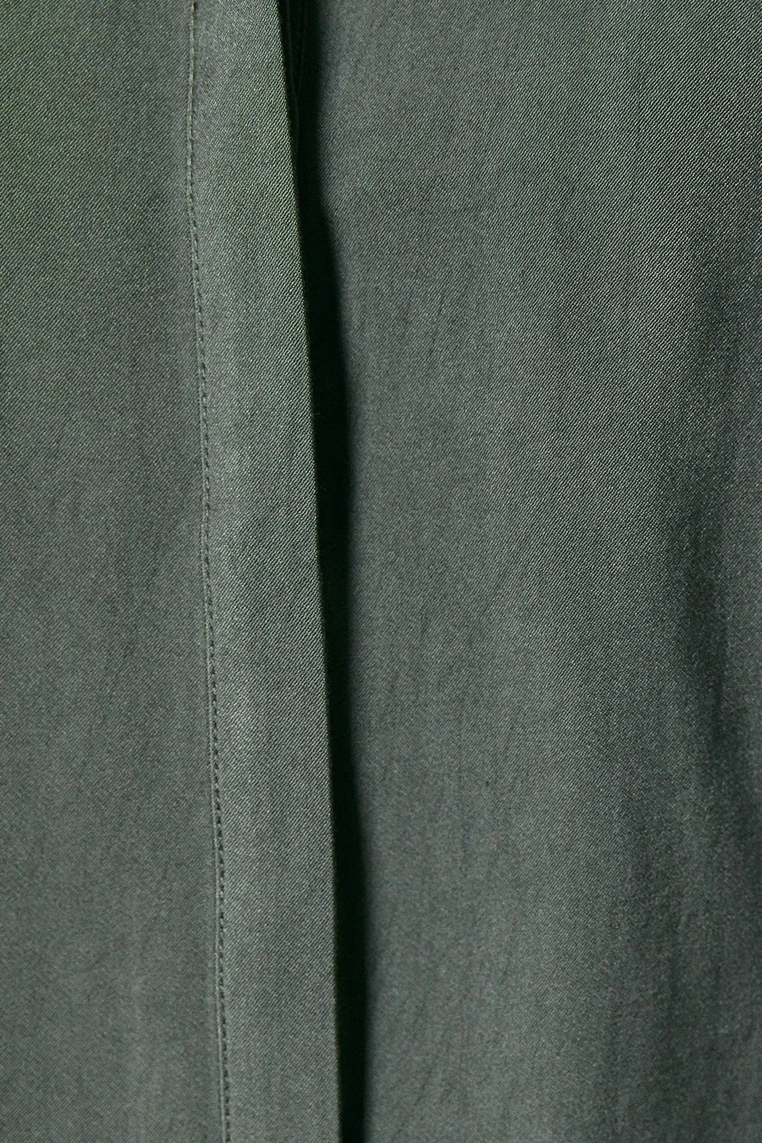 Dark green woven fabric with subtle texture and visible stitching on the collard wide shoulder button down shirt