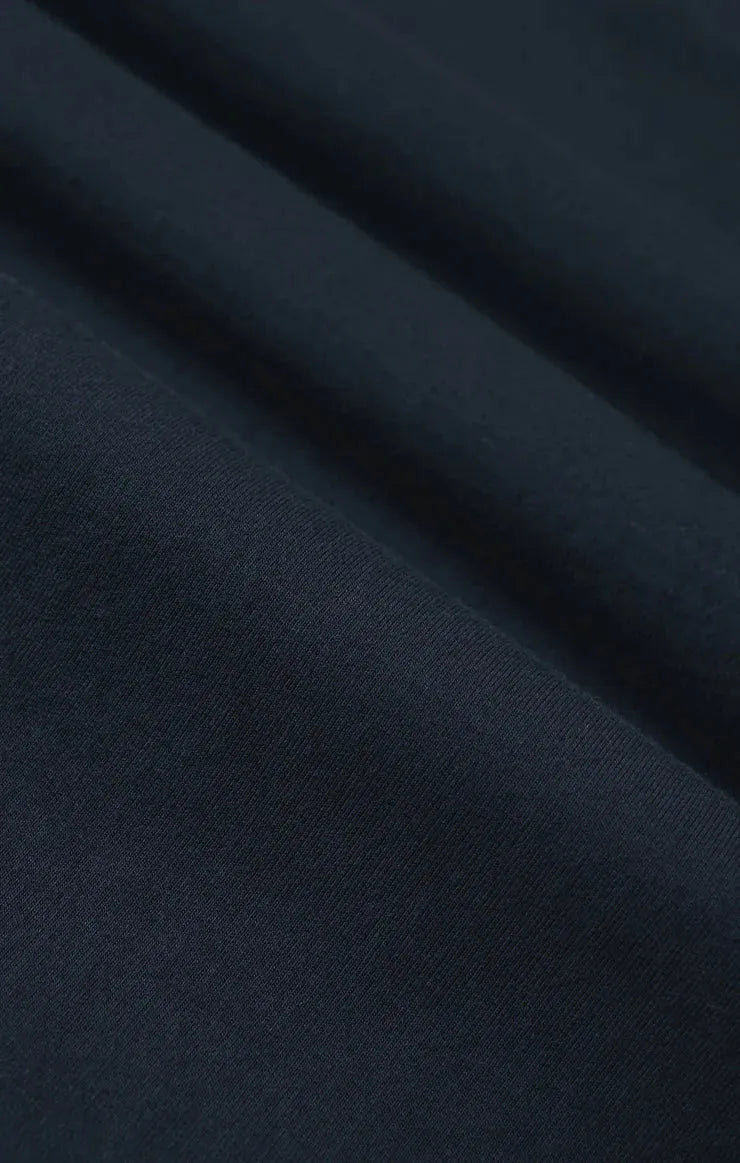 Dark navy blue harbor modal tee fabric with smooth, slightly textured surface and soft folds in modal material