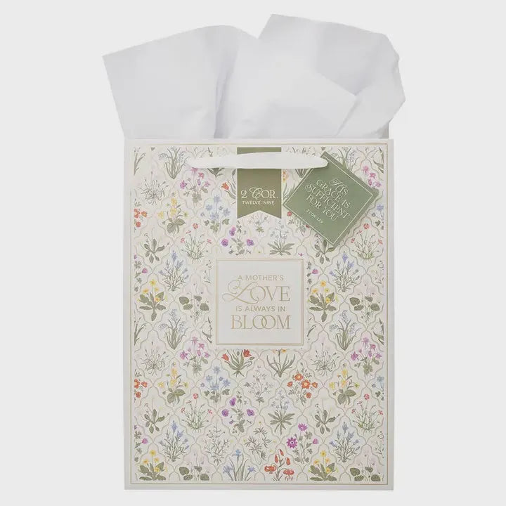 A delicate cream gift bag with pastel floral print celebrating mothers love in the bloom portrait gift design