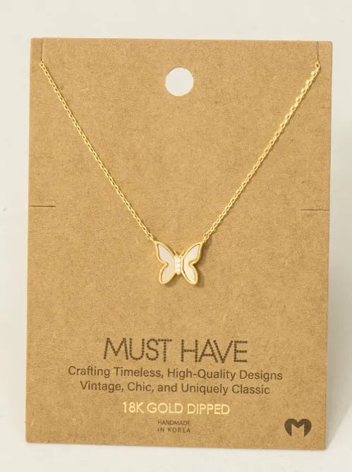 Gold dipped mini butterfly pendant necklace with white enamel center on card