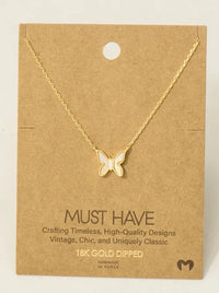 Gold dipped mini butterfly pendant necklace with white enamel center on card