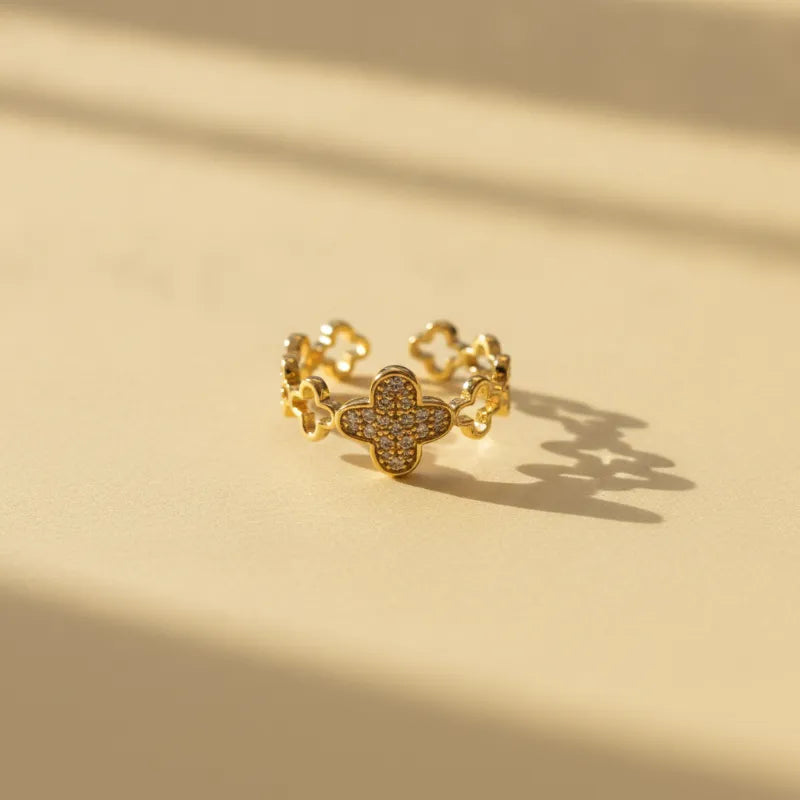 A dazzling crystal pave gold ring featuring a delicate four-leaf clover adorned with sparkling clear stones