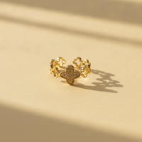 A dazzling crystal pave gold ring featuring a delicate four-leaf clover adorned with sparkling clear stones