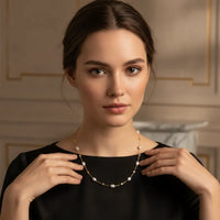 A delicate white pearl gold cube necklace with lustrous pearls and small diamond accents in gold