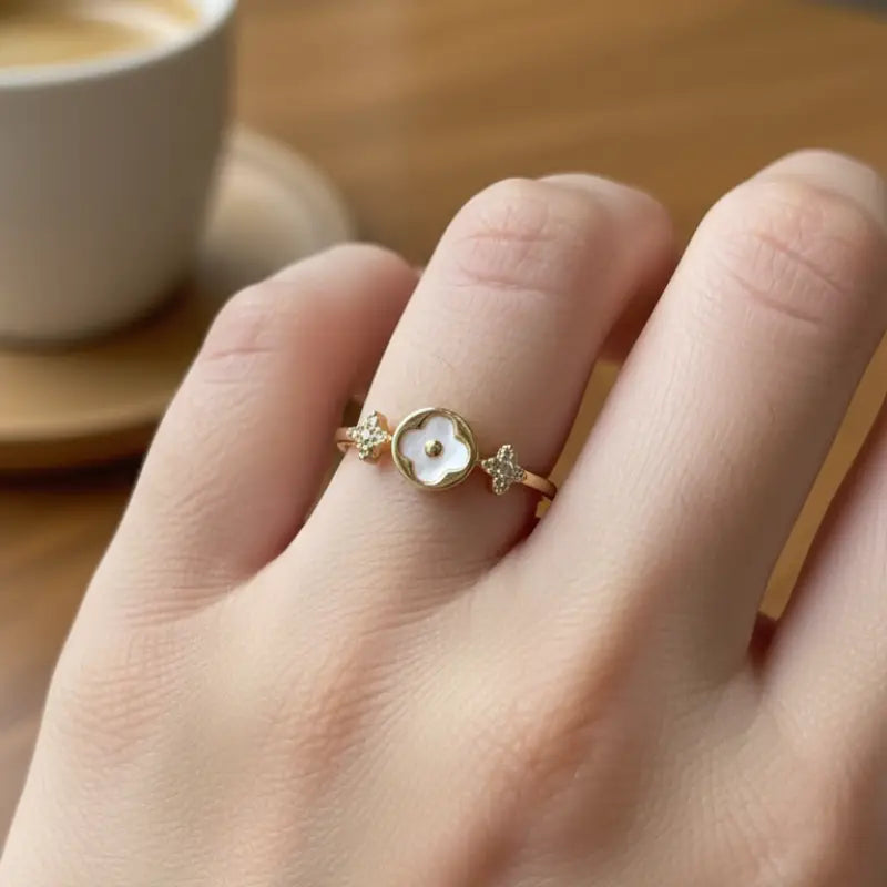 Delicate gold clover adjustable ring with a white mother-of-pearl flower and diamond center flanked by star embellishments