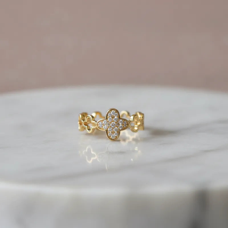 A dazzling crystal pave gold ring featuring a delicate four-leaf clover design with clear sparkling stones