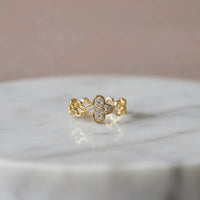 A dazzling crystal pave gold ring featuring a delicate four-leaf clover design with clear sparkling stones