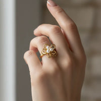 A delicate gold pearl blossom wire ring featuring a floral design with three small white pearls at its center