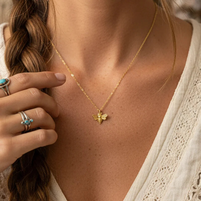 Mini bee gold pendant dainty necklace on skin