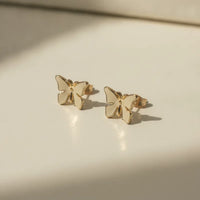 Delicate gold plated butterfly stud earrings with a smooth minimalist design perfect for chic nature-inspired style